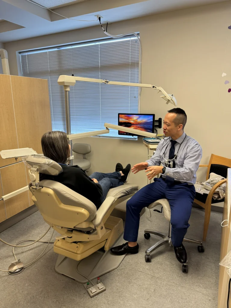 Dr. Cho talking with a patient relaxing in the dental chair