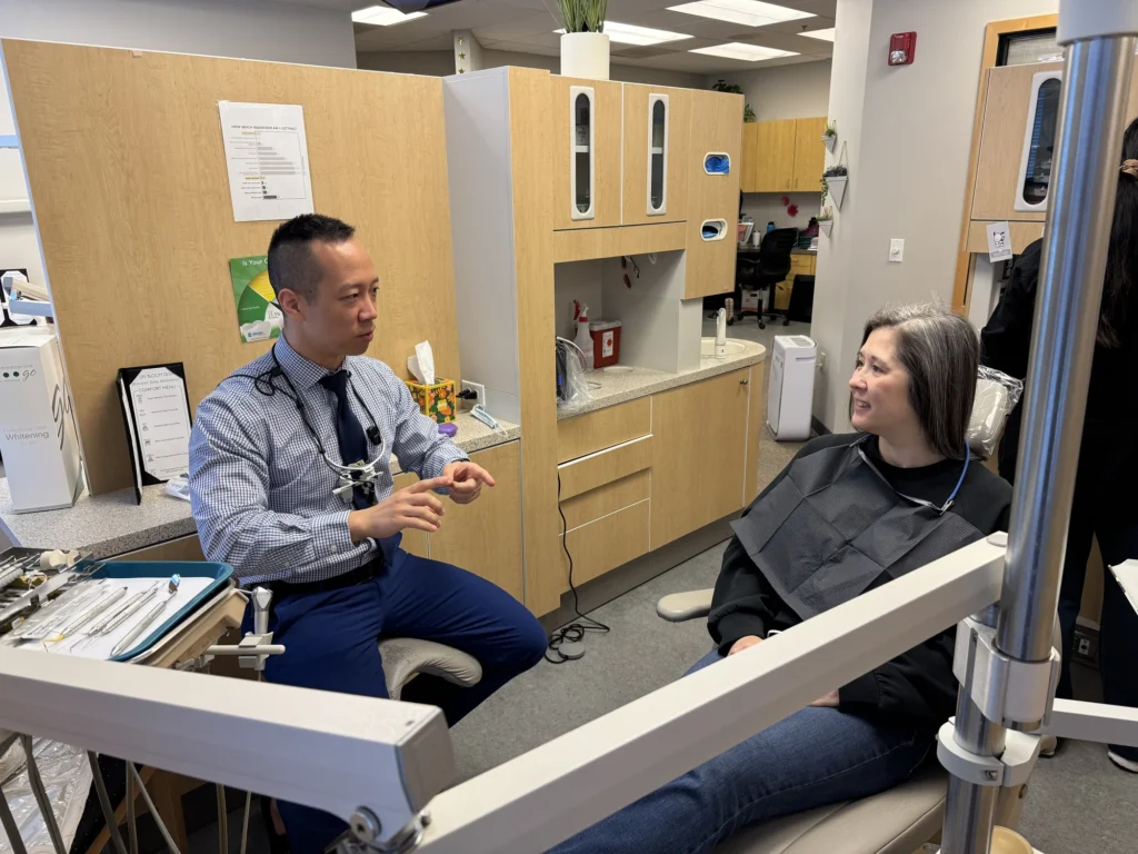 Dr. Cho talking with a patient in the dental chair