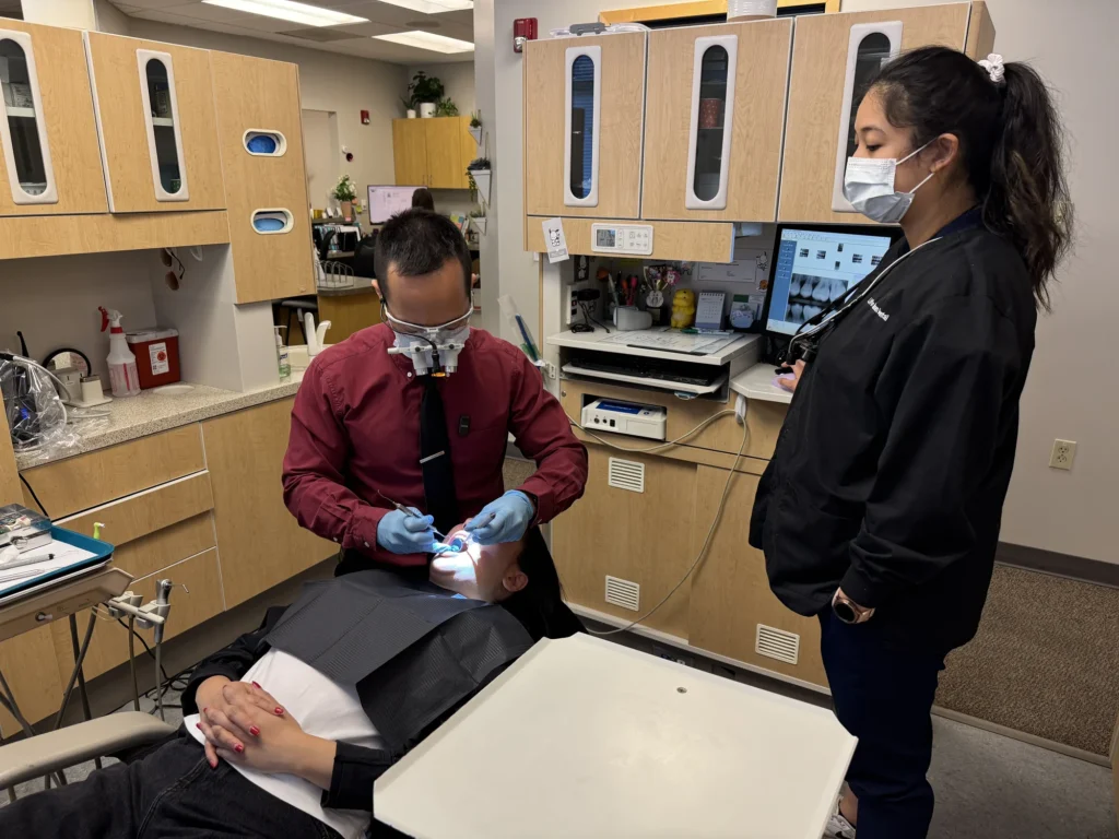 Dr. Cho working under magnification with his assistant beside him