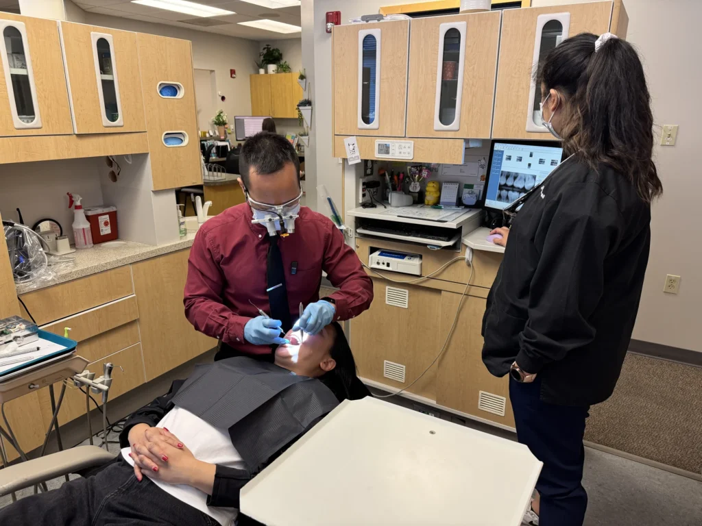 Dr. Cho and his assistant treating a patient in the operatory
