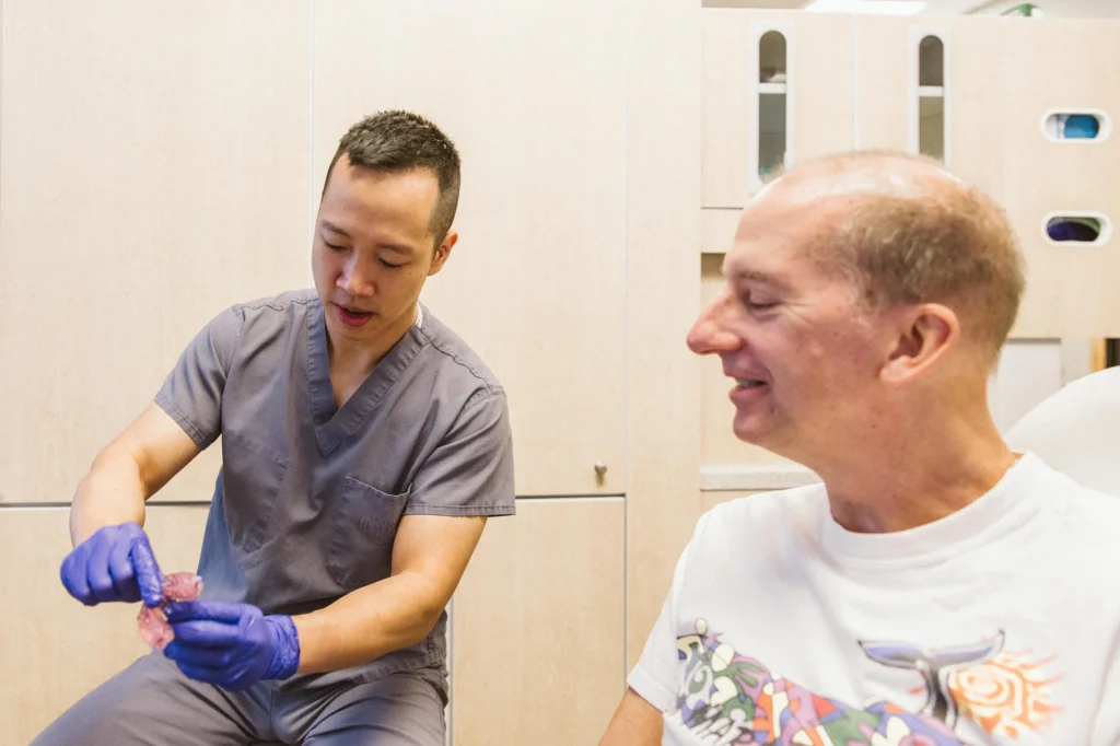 Dr. Cho explaining a treatment to a smiling patient