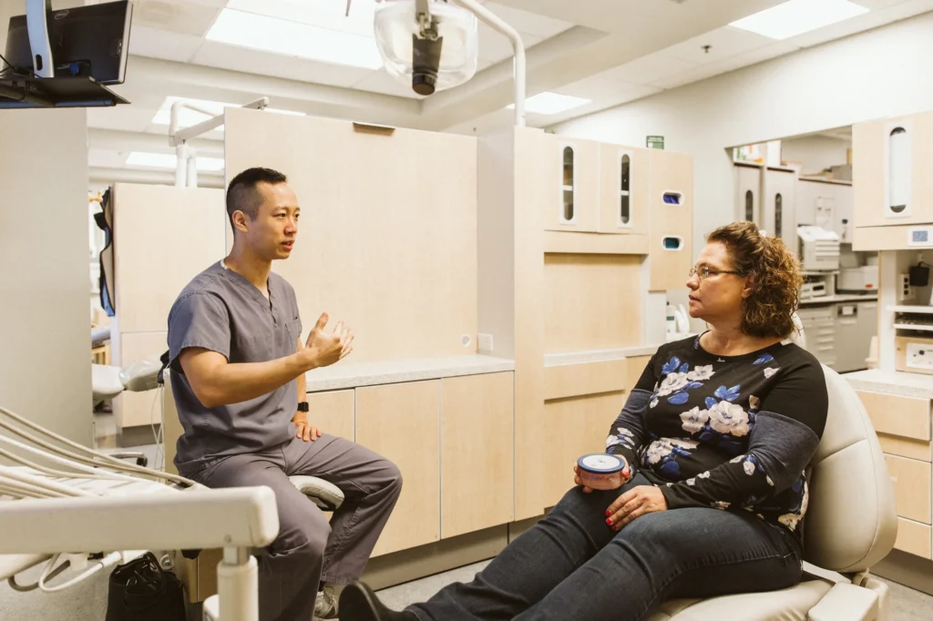 Dr. Cho talking with a patient in the treatment chair