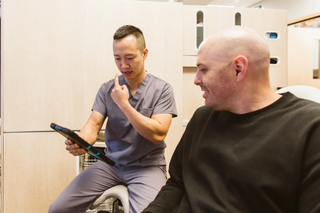 Dr. Cho laughing with a patient as they go over a tablet
