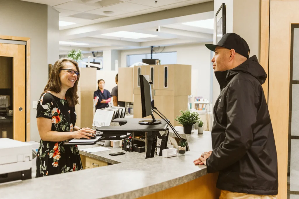 A patient checking in with the front desk team