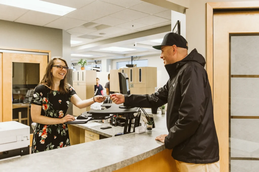 A patient checking in with the front desk team