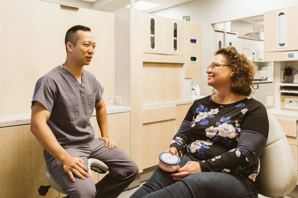 Dr. Cho talking with a patient in the treatment chair