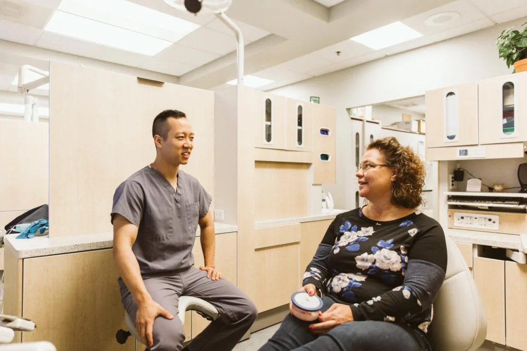 Dr. Cho talking with a patient in the treatment chair