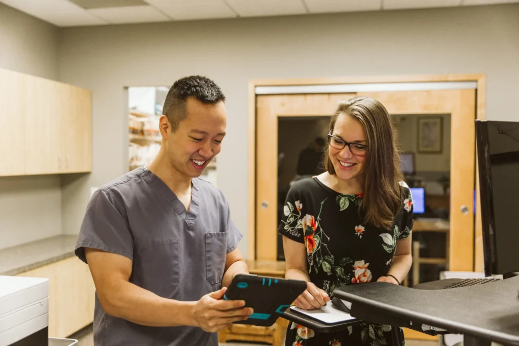Dr. Cho going over a treatment plan with a smiling patient on a tablet