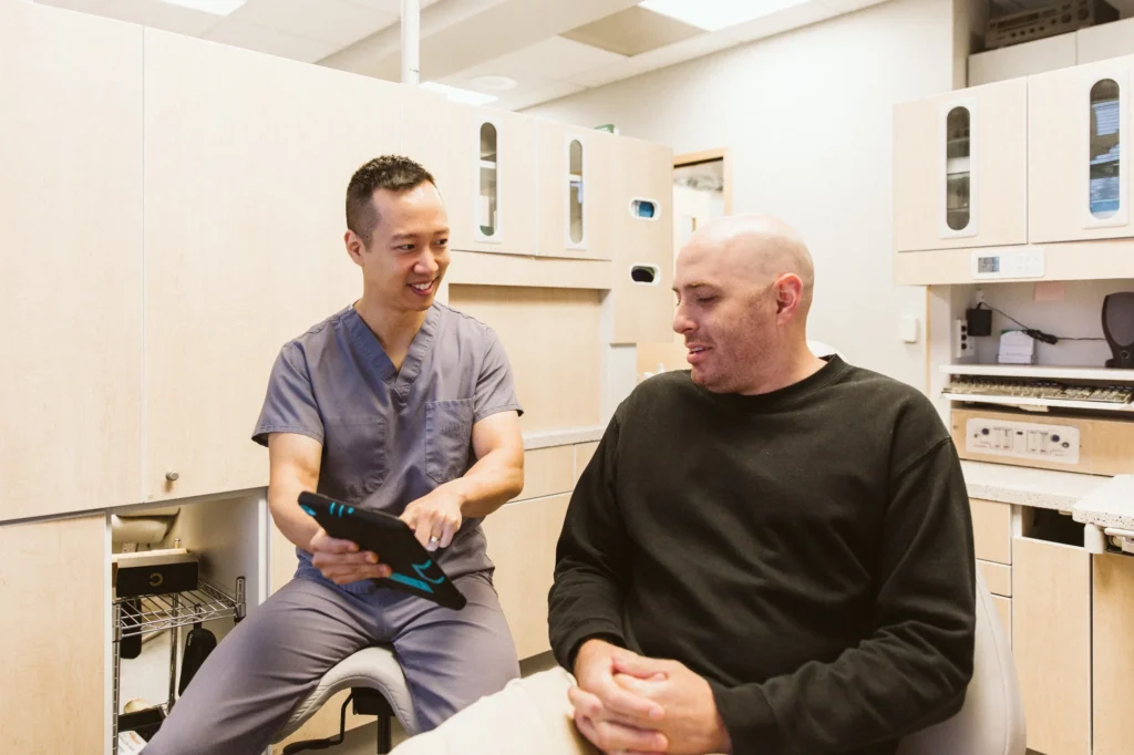 Dr. Cho reviewing a scan with a patient on a tablet